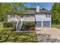 Inviting two-story house showcasing a cozy balcony, gray siding, a stone facade, and a convenient two-car garage at 582 Linda Ln, Powder Springs, GA 30127