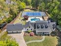 Stunning aerial view of estate featuring pool, tennis court, lush landscaping, and black shingle roof at 4440 Webb Bridge Rd, Alpharetta, GA 30005