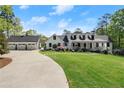 Stunning exterior of a traditional home with lush lawn and a three-car garage at 4440 Webb Bridge Rd, Alpharetta, GA 30005