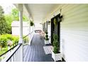 Inviting front porch features a swing, black railings, and a freshly painted floor at 57 Glenn Eagles Way, Hiram, GA 30141