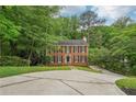 Traditional two-story brick home with black shutters and a spacious driveway at 2895 Shurburne Dr, Alpharetta, GA 30022