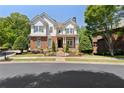 A delightful two-story home with a brick and stone facade, complemented by a well-maintained lawn and mature trees at 4675 Lakeway Pl, Alpharetta, GA 30005