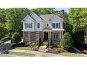 Beautiful home with brick and stone, manicured landscaping, and charming front porch, nestled among mature trees at 4675 Lakeway Pl, Alpharetta, GA 30005
