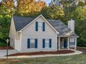 Home featuring a garage, blue shutters, professional landscaping, and a stone facade at 124 Williams Blf, Mcdonough, GA 30252