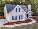 Exterior featuring a garage, blue shutters, professional landscaping, and stone facade at 124 Williams Blf, Mcdonough, GA 30252