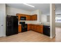 Open concept kitchen with black appliances, wood cabinets, and a breakfast bar, seamlessly connected to the living space at 2419 Ivey Crest Cir, Tucker, GA 30084