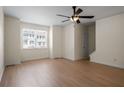 Bright living room featuring hardwood floors, a modern ceiling fan, and a large window offering plenty of natural light at 2419 Ivey Crest Cir, Tucker, GA 30084