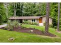 Charming home with updated windows, a landscaped yard, bright orange front door, and a convenient carport at 4228 Durham Cir, Stone Mountain, GA 30083
