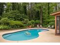 Inviting backyard pool with lounge chairs, lush greenery providing privacy, and a serene atmosphere for relaxation at 4228 Durham Cir, Stone Mountain, GA 30083