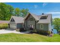 Inviting craftsman-style home with a two-car garage, stone accents, and lush green lawn at 5635 Cherokee Trce, Cumming, GA 30041