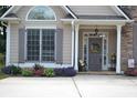 Inviting front porch with flowers, a seat, and a gray front door with glass sidelights and a decorative wreath at 40 Templeton Ln, Villa Rica, GA 30180