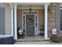 Inviting front porch with bench, flowers, decorative wreath, and a lantern style porch light at 40 Templeton Ln, Villa Rica, GA 30180