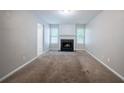 Cozy living room featuring a fireplace, neutral walls and carpeting with natural lighting at 3777 Oakland Spring Ct, Snellville, GA 30039