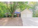 Charming home featuring a two-car garage, brick facade, and mature shade tree at 3856 Vine Stone Dr, Lithonia, GA 30038