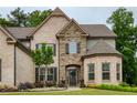 Stunning brick home featuring a stone archway entrance, manicured lawn, and charming curb appeal at 5250 Briarstone Ridge Way, Alpharetta, GA 30022