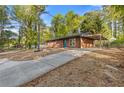 Concrete driveway leads to a charming brick home with a covered carport and wooded surroundings at 622 Saddlewood Dr, Lawrenceville, GA 30043