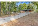 Long driveway leads to a brick ranch-style home with a lush, wooded surround at 622 Saddlewood Dr, Lawrenceville, GA 30043