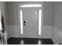 Bright foyer with dark floors, white paneled walls and sidelights accenting a white front door at 3152 Spruce Way, Atlanta, GA 30349
