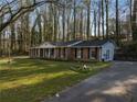 Beautiful brick home with a large front yard, mature trees, swing and a paved driveway at 1351 Stephens Sw St, Lilburn, GA 30047