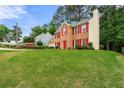 Spacious front yard leading to a classic brick home with red shutters and a manicured lawn at 4805 Wilkie Nw Way, Acworth, GA 30102