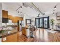 Open-concept living space featuring hardwood floors, a kitchen with island, and doors to a balcony at 5300 Peachtree Rd # 3601, Atlanta, GA 30341