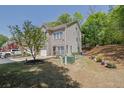 Side view of a two-story townhome with brick facade and well-maintained lawn and landscaping at 1076 Firethorne Pass, Cumming, GA 30040