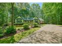 Beautiful yellow home with a green trim, surrounded by lush trees and manicured landscaping at 2795 Autumn Dr, Canton, GA 30115