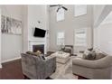 Inviting living room with a cozy fireplace, high ceilings, and comfortable seating arrangement at 4050 Danbury Farms Dr, Cumming, GA 30040