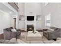 Spacious living room featuring a fireplace, tall ceilings, and neutral decor at 4050 Danbury Farms Dr, Cumming, GA 30040