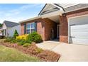Charming brick home with manicured landscaping and attached two-car garage at 806 Village Pl, Loganville, GA 30052