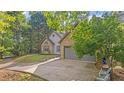 A beautiful home featuring a stone and gray exterior, complemented by a lush yard and a gray two-car garage at 130 Laguna Springs Dr, Woodstock, GA 30188