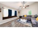 Inviting living room boasts a large window seat, wood floors and comfortable gray sectional at 247 Shallowford Nw Rd, Kennesaw, GA 30144