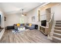 Open living room with cozy seating, staircase and wood-look flooring, ideal for gatherings at 247 Shallowford Nw Rd, Kennesaw, GA 30144