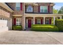 Attractive two story brick home with red shutters, covered porch, and attached two-car garage at 4828 Planters Walk, Douglasville, GA 30135