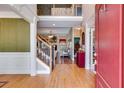 Open foyer with hardwood floors, staircase with wrought iron railing, and view into the living room at 4828 Planters Walk, Douglasville, GA 30135
