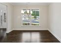 Bright dining room with hardwood floors, modern chandelier, and large window overlooking the neighborhood at 5817 Creek Indian Dr, Sugar Hill, GA 30518