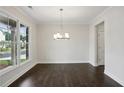 Elegant dining room with hardwood floors, modern chandelier, and large windows at 5817 Creek Indian Dr, Sugar Hill, GA 30518