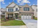 Charming two-story home with brick facade, neat landscaping, and a welcoming front porch at 5817 Creek Indian Dr, Sugar Hill, GA 30518