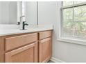 Bathroom featuring wood vanity, black faucet, white countertop, and a bright window at 6125 Brookechase Ln, Norcross, GA 30093