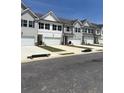 A row of newly constructed townhomes, each featuring individual garages and coordinated architectural styles at 6425 Rosetta Drive, Unit 65, South Fulton, GA 30331