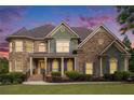 Two-story home with stone and siding accents against a vivid sunset sky at 3820 Preserve Crossing Ln, Cumming, GA 30040