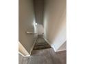 Carpeted stairway illuminated by a wall sconce, featuring neutral paint and white trim, leading to the upper level at 4291 Preserve Trl, Snellville, GA 30039