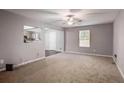Bright living room featuring neutral carpet, soft gray walls and a ceiling fan at 1526 Venetian Sw Dr, Atlanta, GA 30311