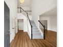 Bright foyer featuring hardwood floors, a staircase with black banisters, and soaring ceilings at 5395 Fontenoy Ct, Peachtree Corners, GA 30071