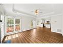 Inviting living room with tray ceilings, large windows, and neutral paint. Hardwood flooring at 5395 Fontenoy Ct, Peachtree Corners, GA 30071