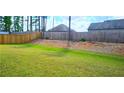 A verdant grassy backyard with a partial wood fence for a serene outdoor space at 632 Eagles Nest Cir, Auburn, GA 30011