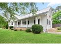 Charming home featuring a metal roof, white siding, front porch, and well-maintained landscaping at 1830 Lost Mountain Rd, Powder Springs, GA 30127