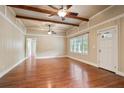 Open living room featuring hardwood floors, wood-beamed ceilings, and lots of natural light at 1830 Lost Mountain Rd, Powder Springs, GA 30127
