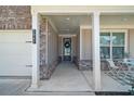 Inviting covered front porch with brick details, seating, and a view of the home's exterior at 2947 Knob Creek Dr, Snellville, GA 30078