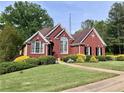 Charming brick home featuring manicured landscaping, lush green lawn, and refined architectural details at 3515 Brandywine Nw Rd, Kennesaw, GA 30144